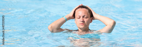 Portrait of woman with closed eyes in water park in pool. Recreation in water parks concept