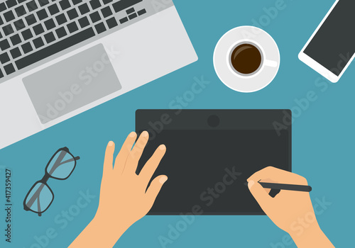 Flat design illustration of hand graphic drawing on digital tablet. Laptop keyboard with glasses and mobile phone. Cup of coffee on the work table, vector