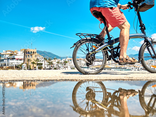Cyclist rides next to puddle which is reflected