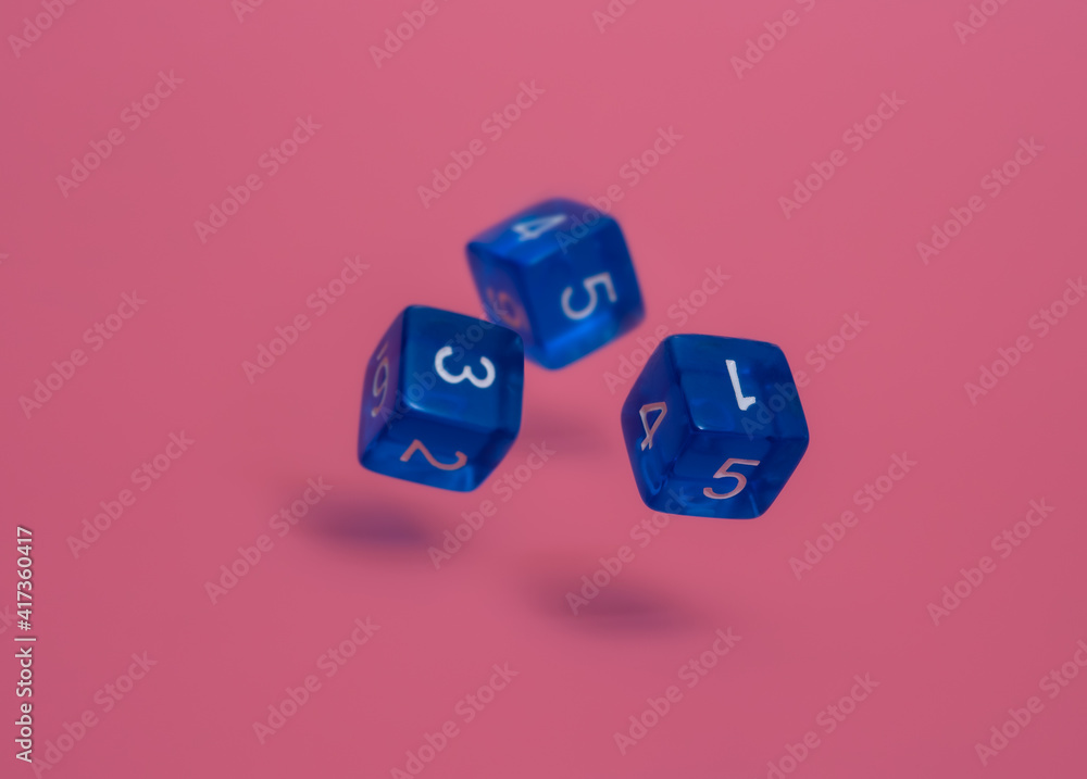 Three blue dices fall on pink background. Three blue dices fall on pink background.