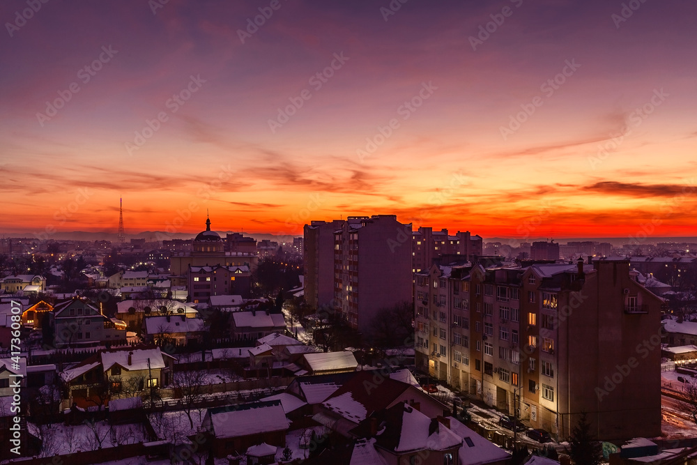 Incredible sunset on the winter city. Evening illuminated city and sunset