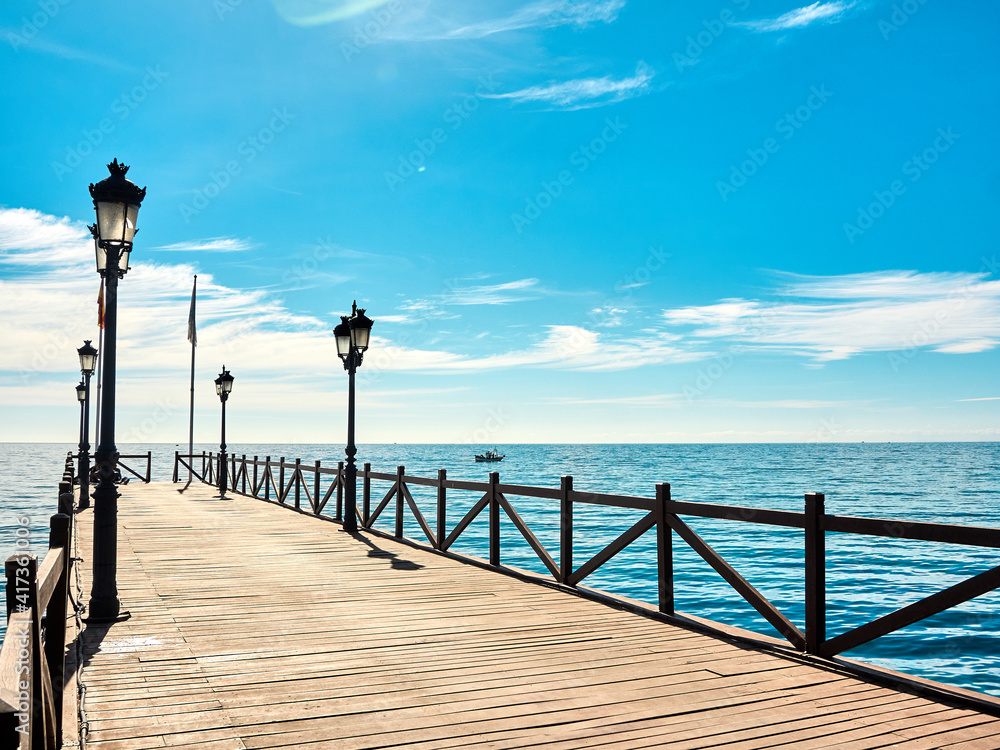 Sandy beach and wooden pier on the Costa del Sol in Marbella, Spain