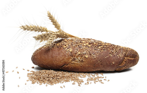 Integral rye bread loaf with seeds, spelt grain and wheat ears isolated on white background