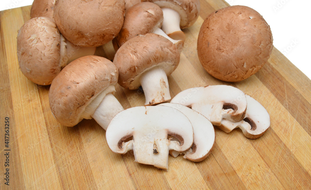 Baby bella mushrooms sliced on wooden board Baby bella mushrooms sliced on wooden board