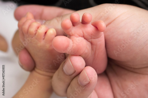 Father holds his baby's foot. Newborn toes in parent's hands