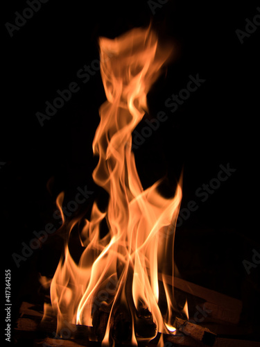 Burning wood and flames in a fireplace. Focus on burning wood