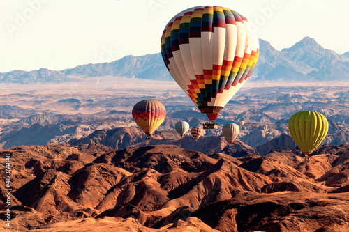 Colorful balloons flying over the moon valley mountain. Africa. Namibia.