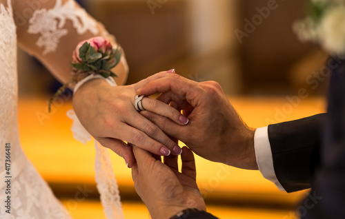 Wedding rings in the hands of the bride and groom. Wearing wedding rings, gentle touches, hands of the bride