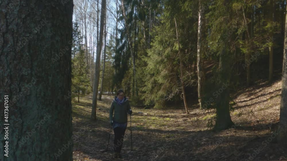 Happy woman practices Nordic walking in early spring forest. Healthy lifestyle, prevention of cardiovascular diseases, during pandemic isolation.
Happy woman practices Nordic walking in early spring forest. Healthy lifestyle, prevention of cardiovascular diseases, during pandemic isolation.