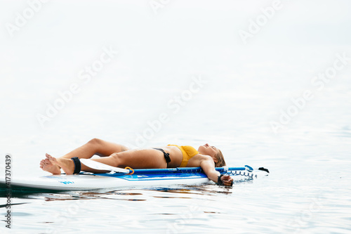 Sporty woman on glanders surfboard at sea photo