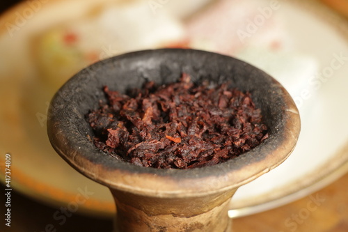 bowl with hookah tobacco. berries on a black background. nargile smoking