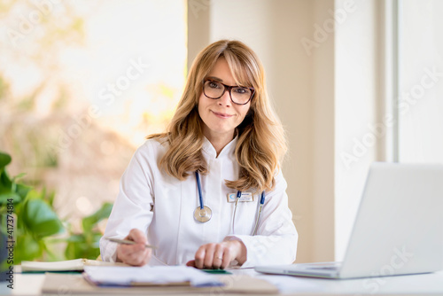 Smiling female doctor portrait while working in doctor's office