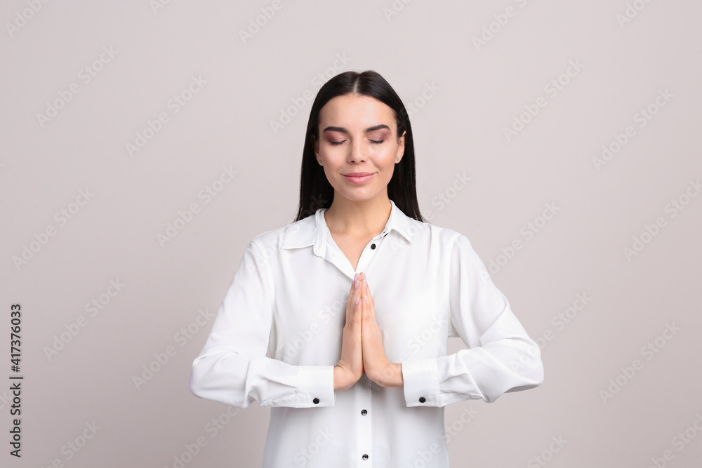 Young woman meditating on beige background. Stress relief exercise Young woman meditating on beige background. Stress relief exercise