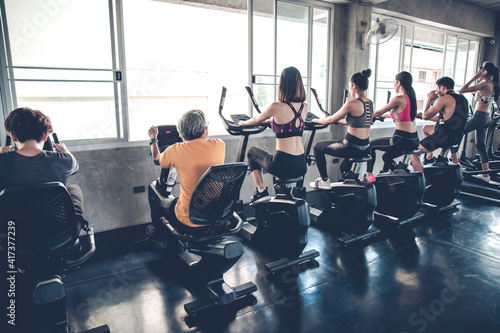 People working out at spinning class in the gym.