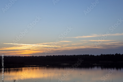 Dramatic and colorful sunset over a forest lake reflected in the water. Blakheide  Beerse  Belgium. High quality photo