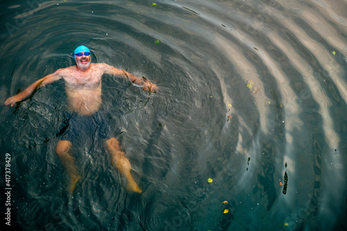 Man wild swimming in river, overhead view, River Wey, Surrey, UK photo