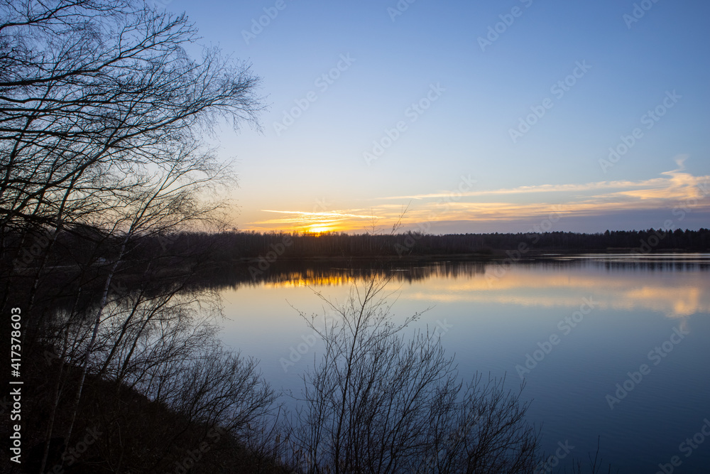 Dramatic and colorful sunset over a forest lake reflected in the water. Blakheide, Beerse, Belgium. High quality photo