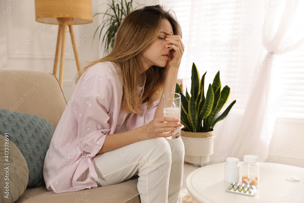 Woman holding glass of medicine for hangover at home Woman holding glass of medicine for hangover at home