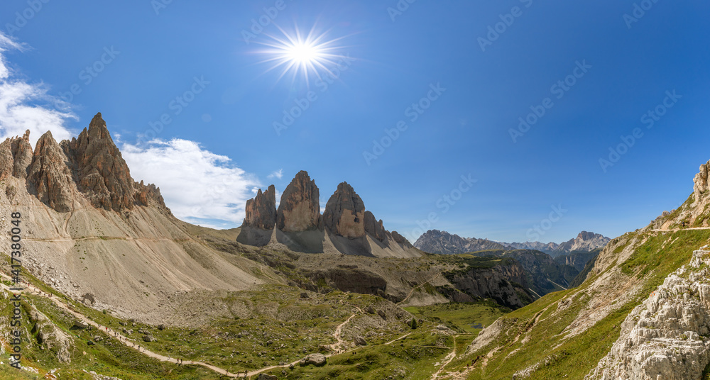 Panoramic view of Tre Cime di Lavaredo under midday sun with tourist trails. Italian Dolomites. South Tyrol, Italy Panoramic view of Tre Cime di Lavaredo under midday sun with tourist trails. Italian Dolomites. South Tyrol, Italy