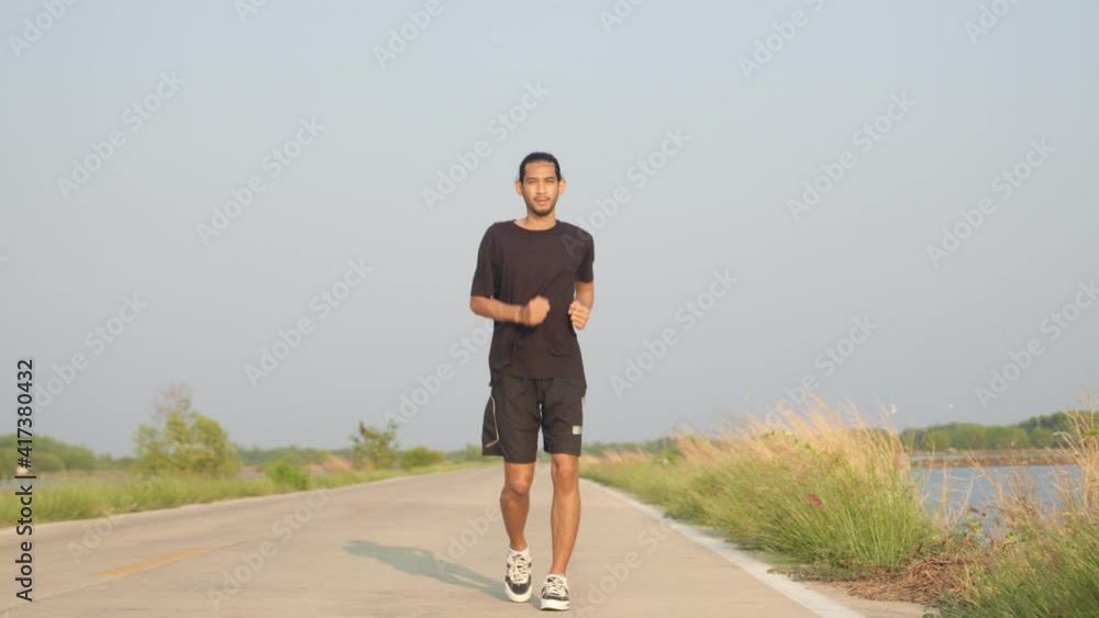 Asian runner runs on street in countryside with fresh and clear air, man running or workout for good healthy, healthy care concept Asian runner runs on street in countryside with fresh and clear air, man running or workout for good healthy, healthy care concept