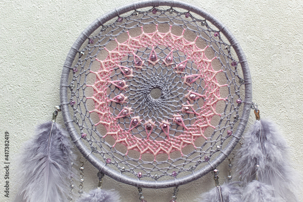 Handmade dream catcher with feathers threads and beads rope hanging on white background Handmade dream catcher with feathers threads and beads rope hanging on white background