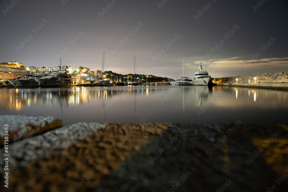 Long exposure at night at the Port of Portals in Calvia with a lighthouse, Palmanova and the stars in the background in Palma de Mallorca, Spain