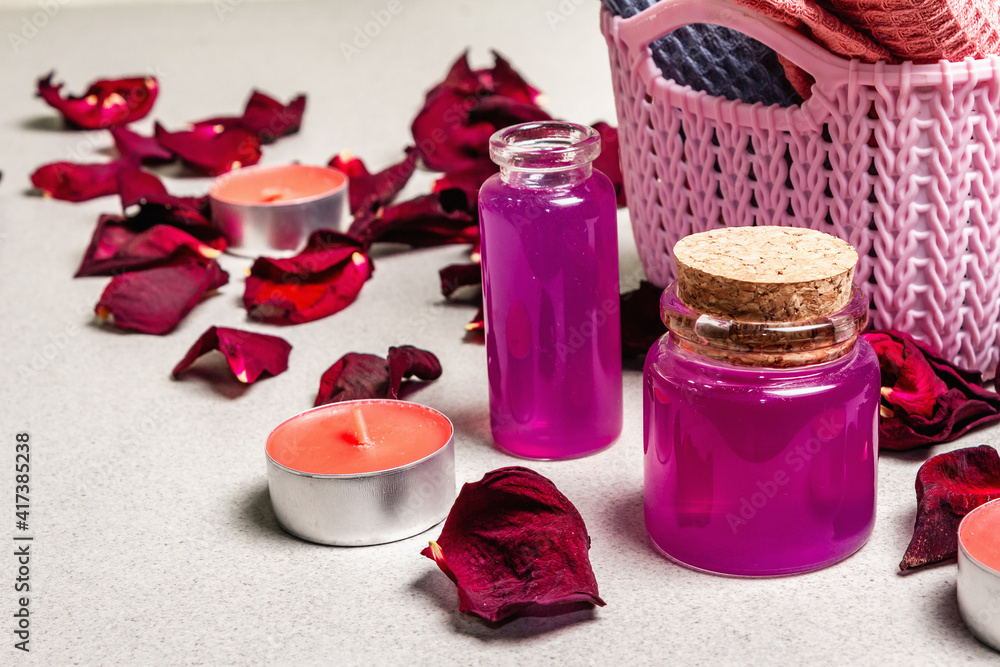 Floral and spa concept with dried roses petals, fragrant candles and soft towel Floral and spa concept with dried roses petals, fragrant candles and soft towel