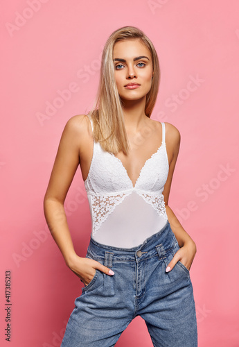 Beautiful blonde female model wear white underwear and jeans isolated on  background © kiuikson