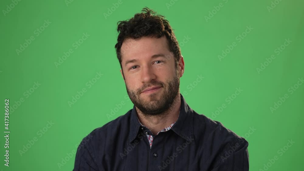 Handsome dreamful bearded young guy 20s in hoodie isolated on green screen chroma key background in studio. People sincere emotions, lifestyle concept. Smiling looking at the camera. Handsome dreamful bearded young guy 20s in hoodie isolated on green screen chroma key background in studio. People sincere emotions, lifestyle concept. Smiling looking at the camera.