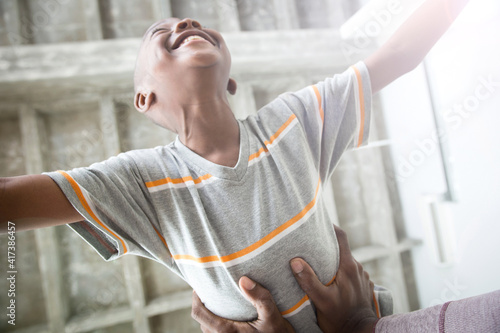 Hands holding boy round waist photo