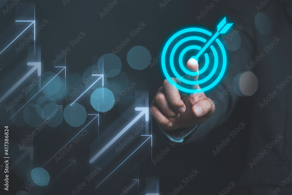 © Dilok - Businessman touching virtual dartboard with arrow ,Business Achievement objective target concept.