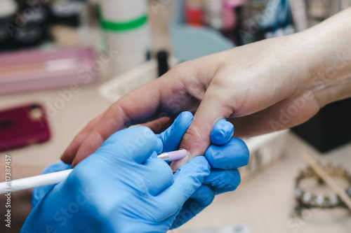 A manicurist makes the client s cuticle close-up