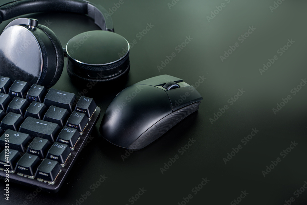 Gaming and gamer devices concept. Gamer work table space background, top view. Keyboard, mouse, gamepad joystick, mouse pad and headphones. on black table background with copy space for text Gaming and gamer devices concept. Gamer work table space background, top view. Keyboard, mouse, gamepad joystick, mouse pad and headphones. on black table background with copy space for text