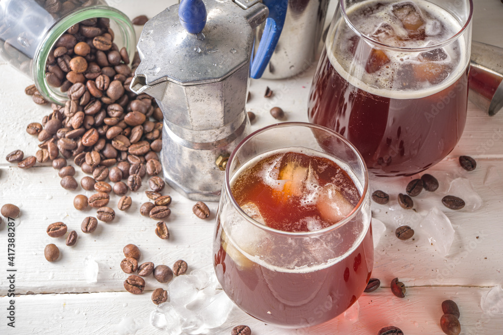 Iced americano espresso coffee without milk, with ice cubes, on white kitchen table background copy space. Black cold brew coffee with ice cubes. Iced americano espresso coffee without milk, with ice cubes, on white kitchen table background copy space. Black cold brew coffee with ice cubes.