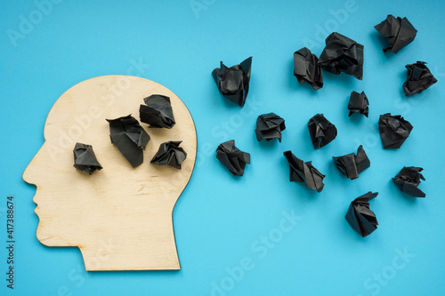 Head shape with black paper balls as symbol of depression and negative thoughts.