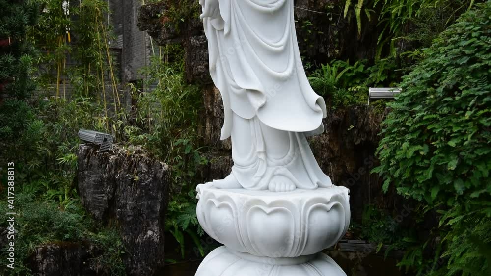 Outdoor stone statue of Guanyin, the oriental mythological figure Outdoor stone statue of Guanyin, the oriental mythological figure