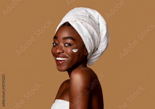 Beautiful young african american woman with cream on cheek