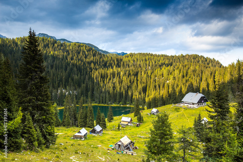 Chalet standing next to the mountain lake with forest. Koca na Planini pri Jezeru. photo