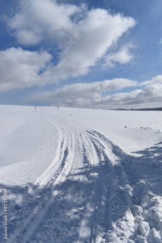 A snowmobile trail under a blue sky, Québec