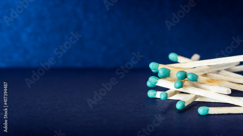 A pile of matches on a blue background. Green sulfur on matches.