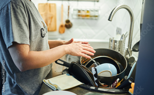 Young woman washing dishes in the kitchen.