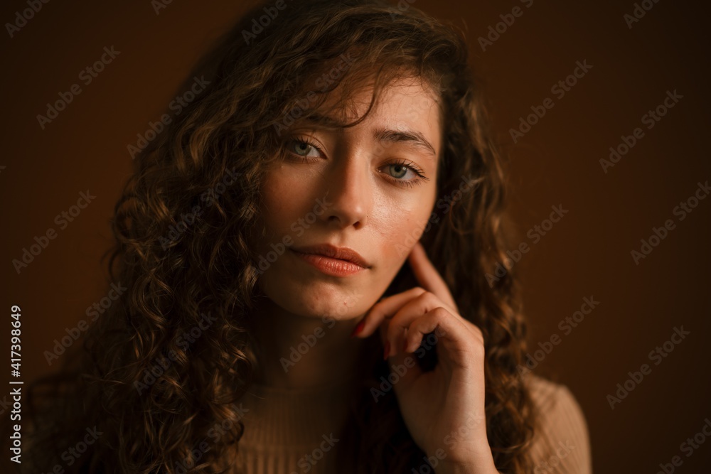 Studio portrait of young woman with long curly hair Studio portrait of young woman with long curly hair