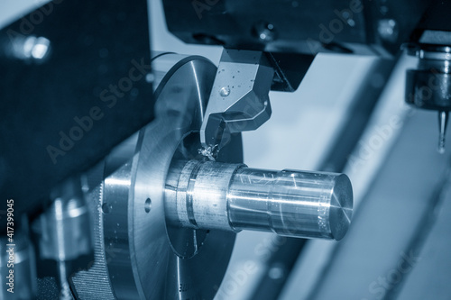Fotografi The  CNC lathe machine slot cutting the metal shaft parts