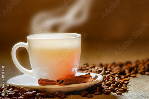 Coffee cup and coffee beans on a wooden table and sack background  Vintage color tone