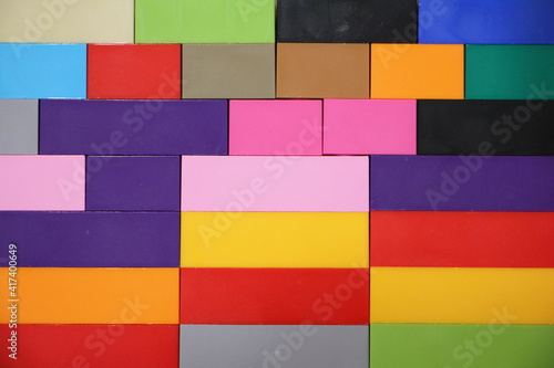 Colorful plastic bricks horizontal lines wall surface, children's construction kit background texture mosaic block