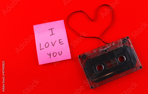 Audio cassette with a film heart and the inscription "I love you" on a red background