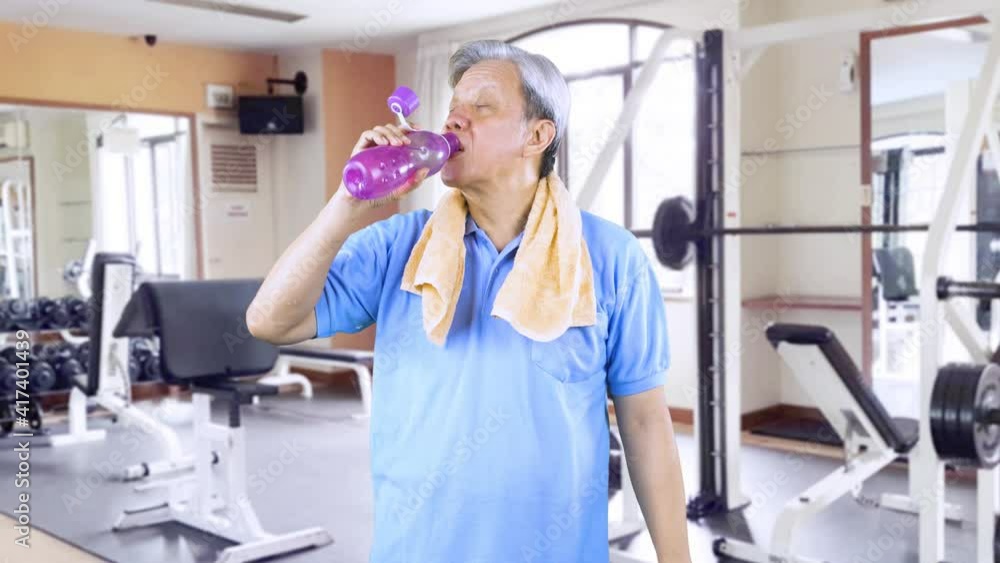 Senior man drink water after exercise in gym center