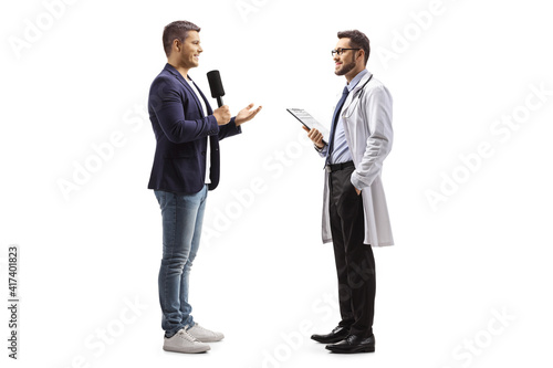 Full length profile shot of a male reporter interviewing a doctor photo