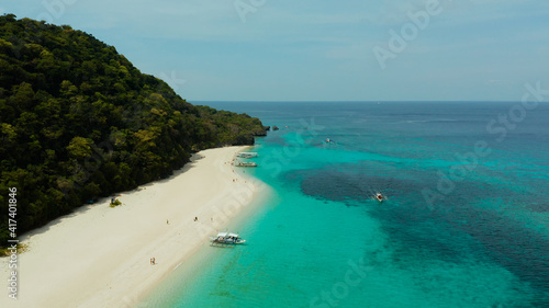 Sandy beach and turquoise water in the tropical resort of Boracay  Puka shell beach  Philippines aerial view. White beach with tourists. Summer and travel vacation concept.