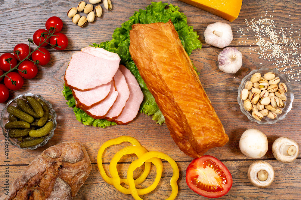 Assortment of cold cuts, a variety of processed cold meat products. On a wooden background Assortment of cold cuts, a variety of processed cold meat products. On a wooden background